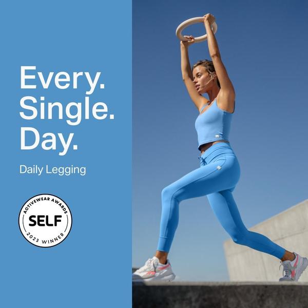 A high-contrast 1:1 image featuring a model wearing leggings while performing a yoga move, highlighting a 2023 industry award.